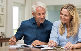 Retired couple sitting at home going through their finances and investment management services